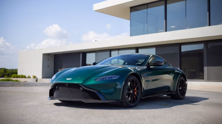 Green-Aston-Martin-Vantage-luxury-grand-tourer-parked-outside-a-modern-estate