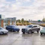 Best fully electric cars of 2026 charging at a modern EV station with city and motorway scenery in the background.
